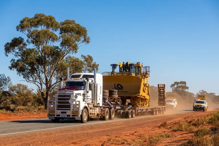 Heavy haulage truck transporting oversized mining equipment on a multi axle low loader in Western Australia
